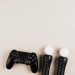 Black gaming controllers arranged on a light background with ample copy space.
