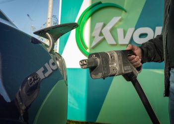 Close-up of an electric car being charged at a public station.