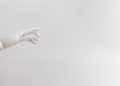 Minimalist image of a robotic hand reaching out on a white background.