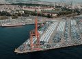 Aerial view of a bustling car shipping terminal in Istanbul, Türkiye, showcasing a busy port with vehicles ready for export.