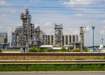 Image of a large chemical factory in Schwechat, Austria, showcasing industrial pipes and machinery.