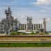 Image of a large chemical factory in Schwechat, Austria, showcasing industrial pipes and machinery.