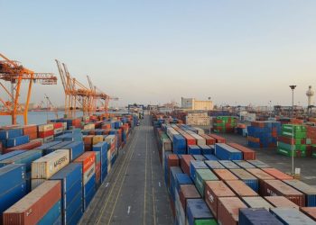 A bustling port scene with colorful cargo containers at sunrise. Ideal for logistics concepts.