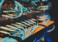 Closeup of many cables with blue wires plugged in modern switch with similar adapters on blurred background in modern studio