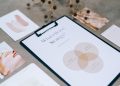 A close-up view of a brand strategy document on a desk surrounded by design artworks.