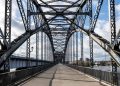 A striking steel arch bridge structure in Hamburg, Germany, under a bright sky.