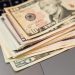 Stack of US dollar bills on a keyboard, symbolizing digital finance and wealth.